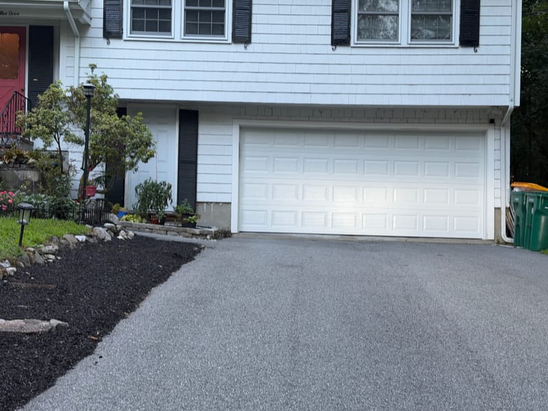 New white 16-foot insulated garage door on a split-level house in Acton, MA