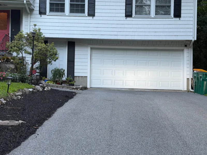 New white 16-foot insulated garage door on a split-level house in Acton, MA