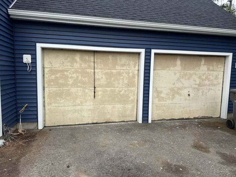 Before: two worn, faded garage doors on a navy two-car garage