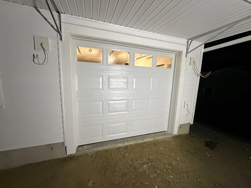 New white garage door with windows on a newly built garage