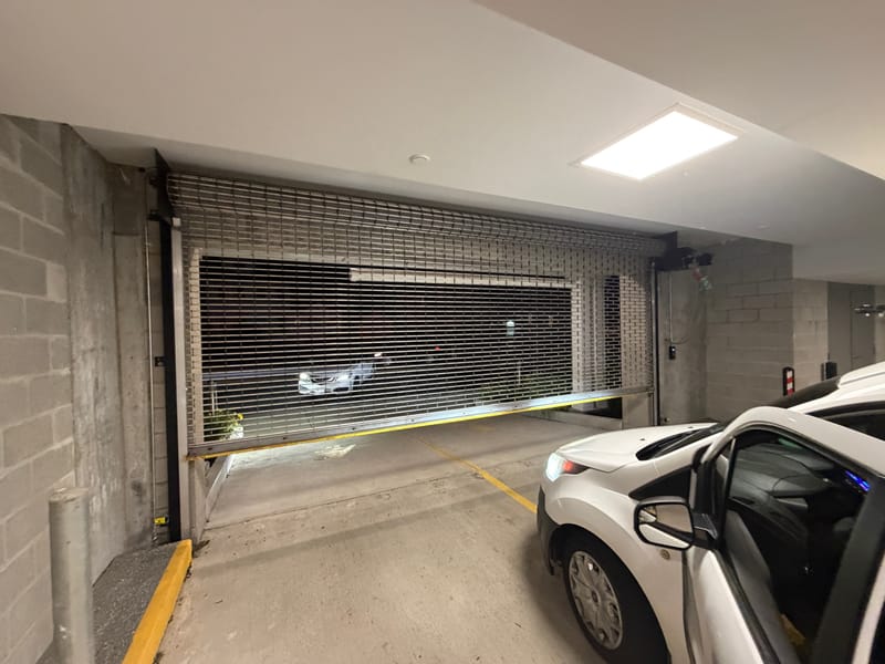 Rolling security grille closed across a parking garage entrance